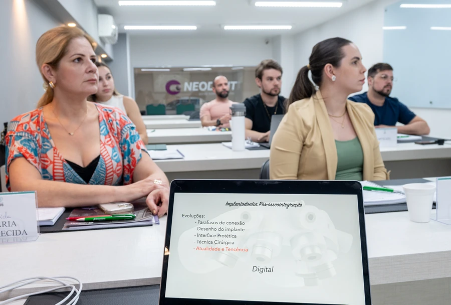 Tela de um tablet mostrando tópicos de Implantodontia, com foco em evoluções como técnicas cirúrgicas e atualidade, durante uma aula no Instituto IPPO.