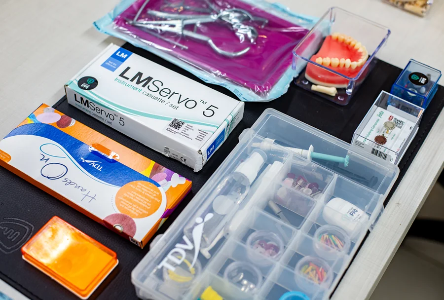 Mesa organizada com diversos materiais odontológicos e ferramentas dispostas para uso durante o treinamento no Instituto IPPO.